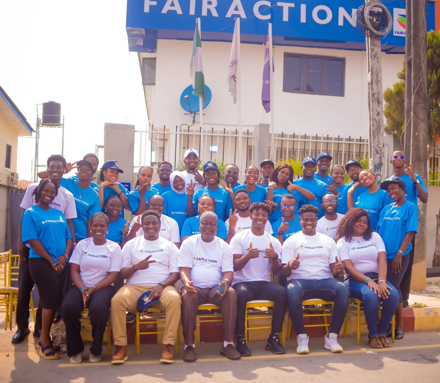 A group photograph of the Fairaction team in front of the Nigeria office, wearing Fairaction-branded shirts. Photo courtesy of Fairaction Nigeria, used with informed consent.