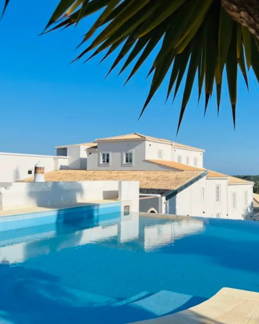 Swimming pool framed by palm trees at Solar Alvura, Algarve