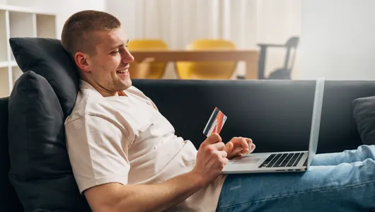 Man sitting on a couch purchasing online