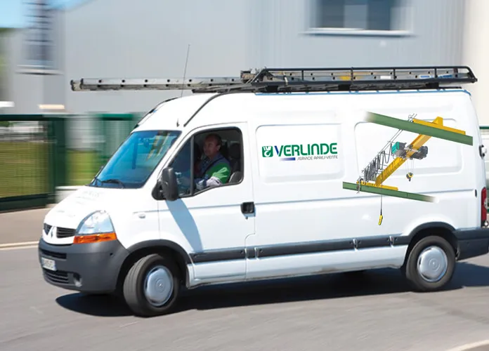White delivery van with "VERLINDE" logo and crane image on the side, driving on a road with a ladder secured on top.