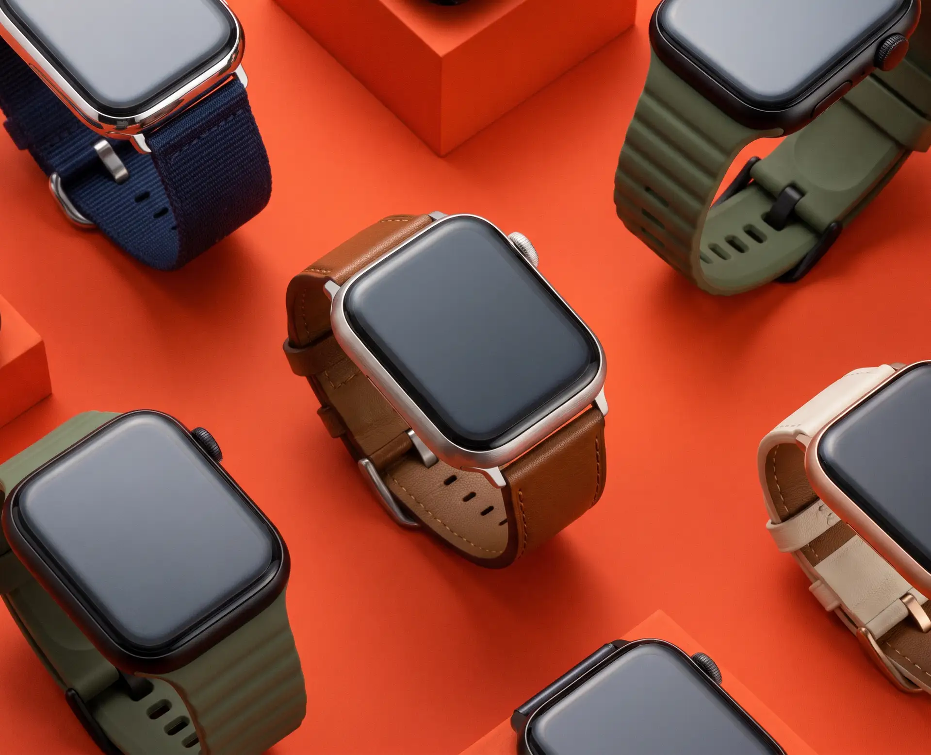 Various smartwatches with different colored bands are arranged on an orange background.