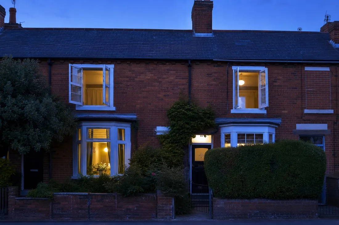 Open windows at dusk venting the day's heat from a home