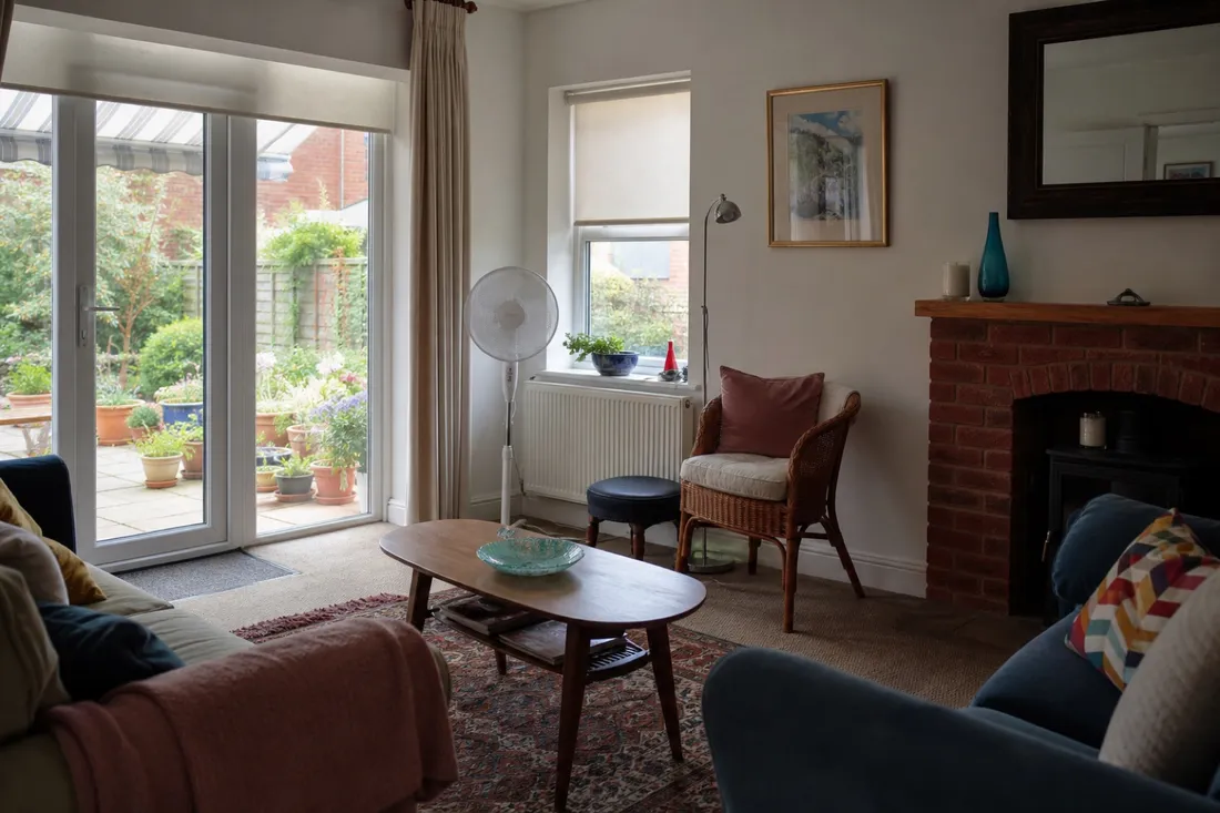 A pedestal fan helping move air through a living room
