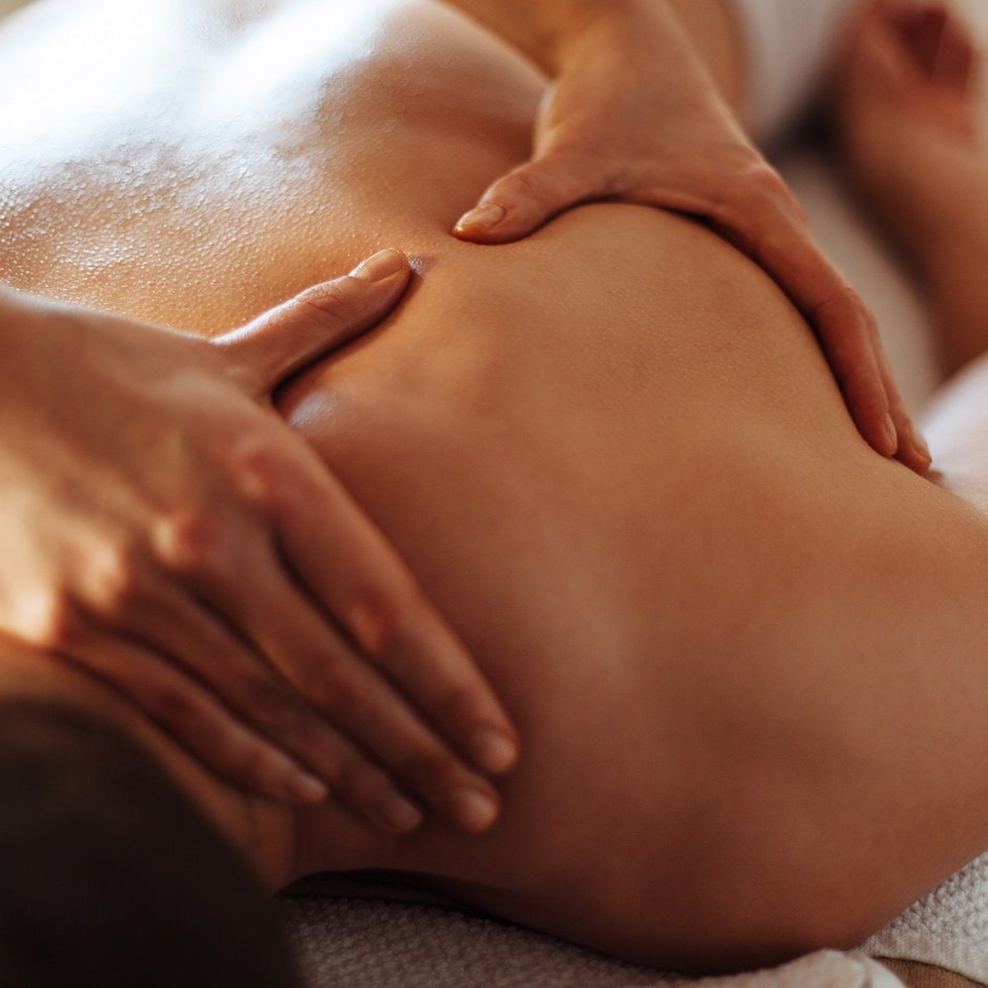 Therapist applying firm pressure during a deep tissue back massage at an at-home treatment