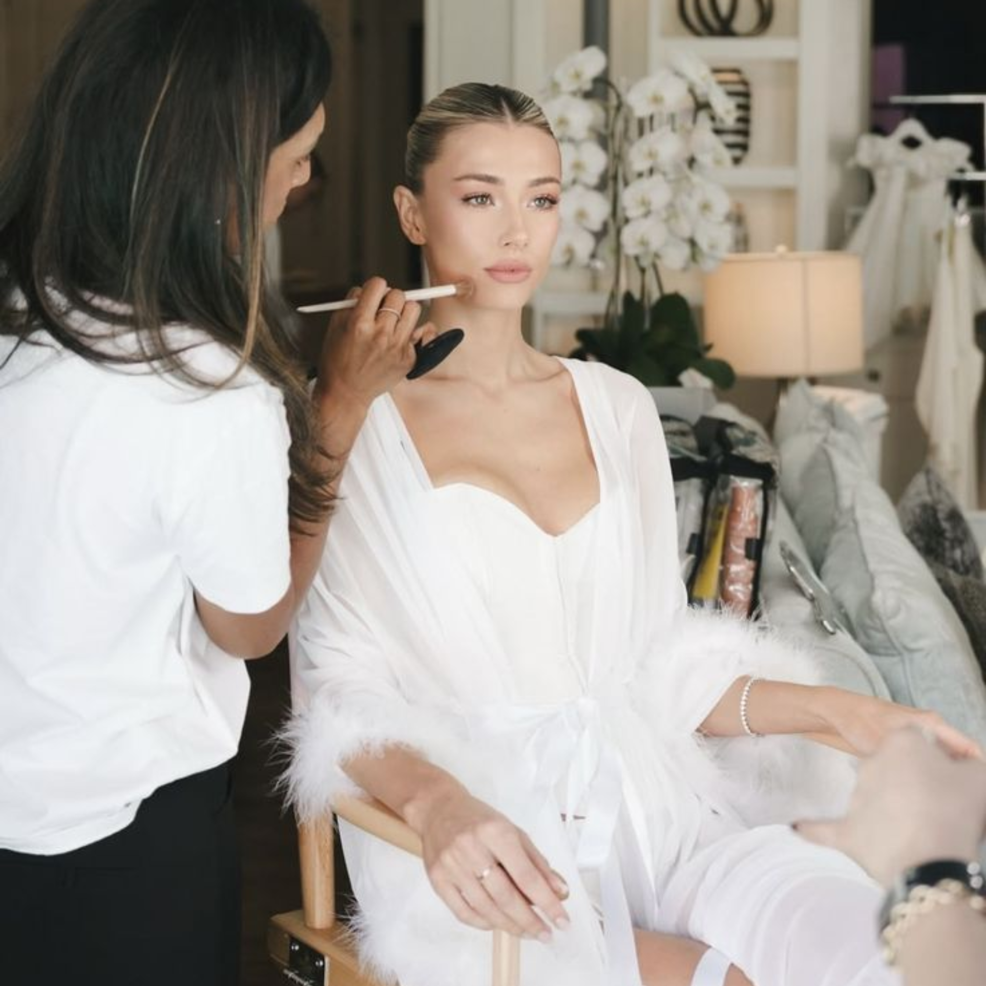 Makeup artist applying bridal makeup to a bride getting ready on the wedding morning