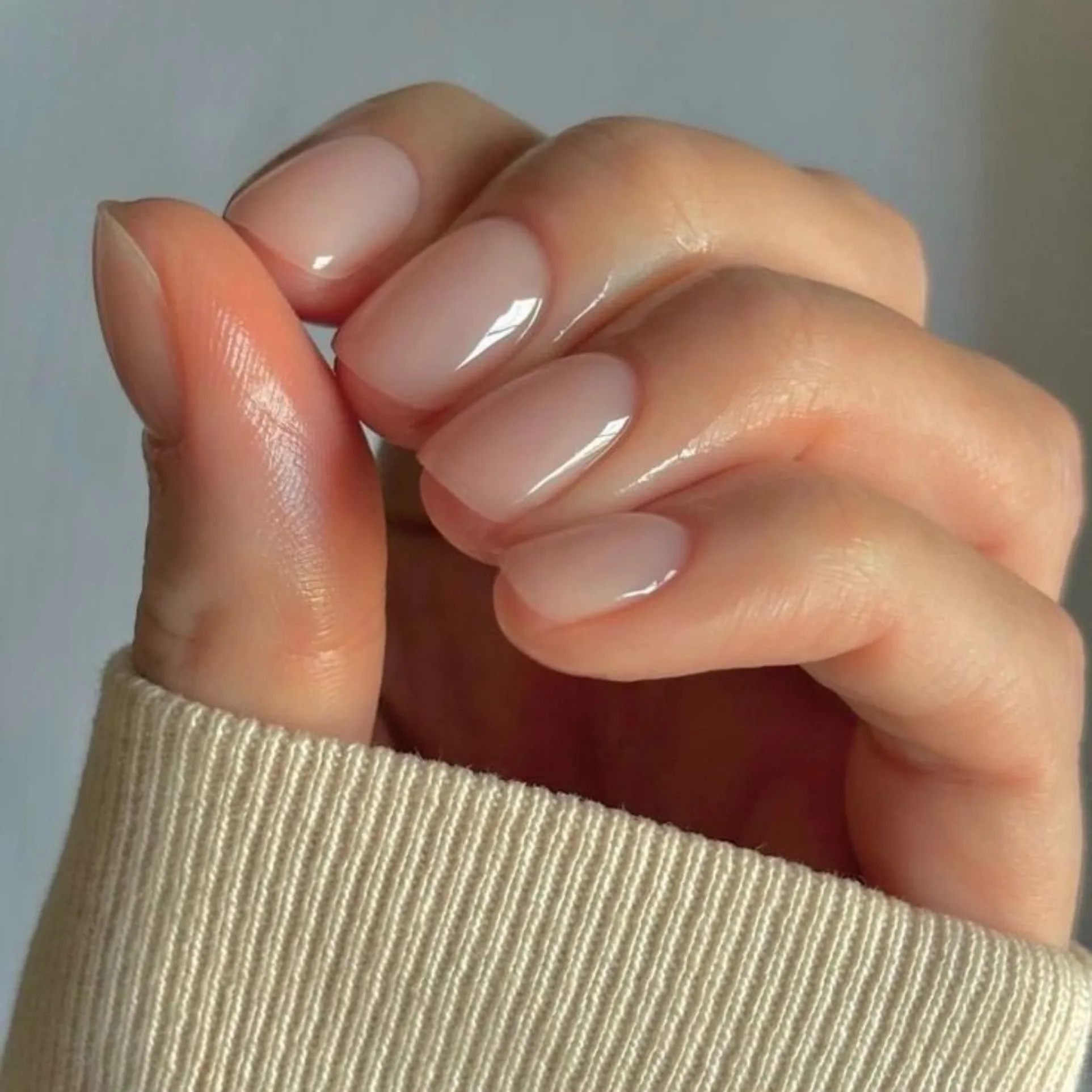 Close-up of natural nails with a glossy sheer finish after a classic manicure