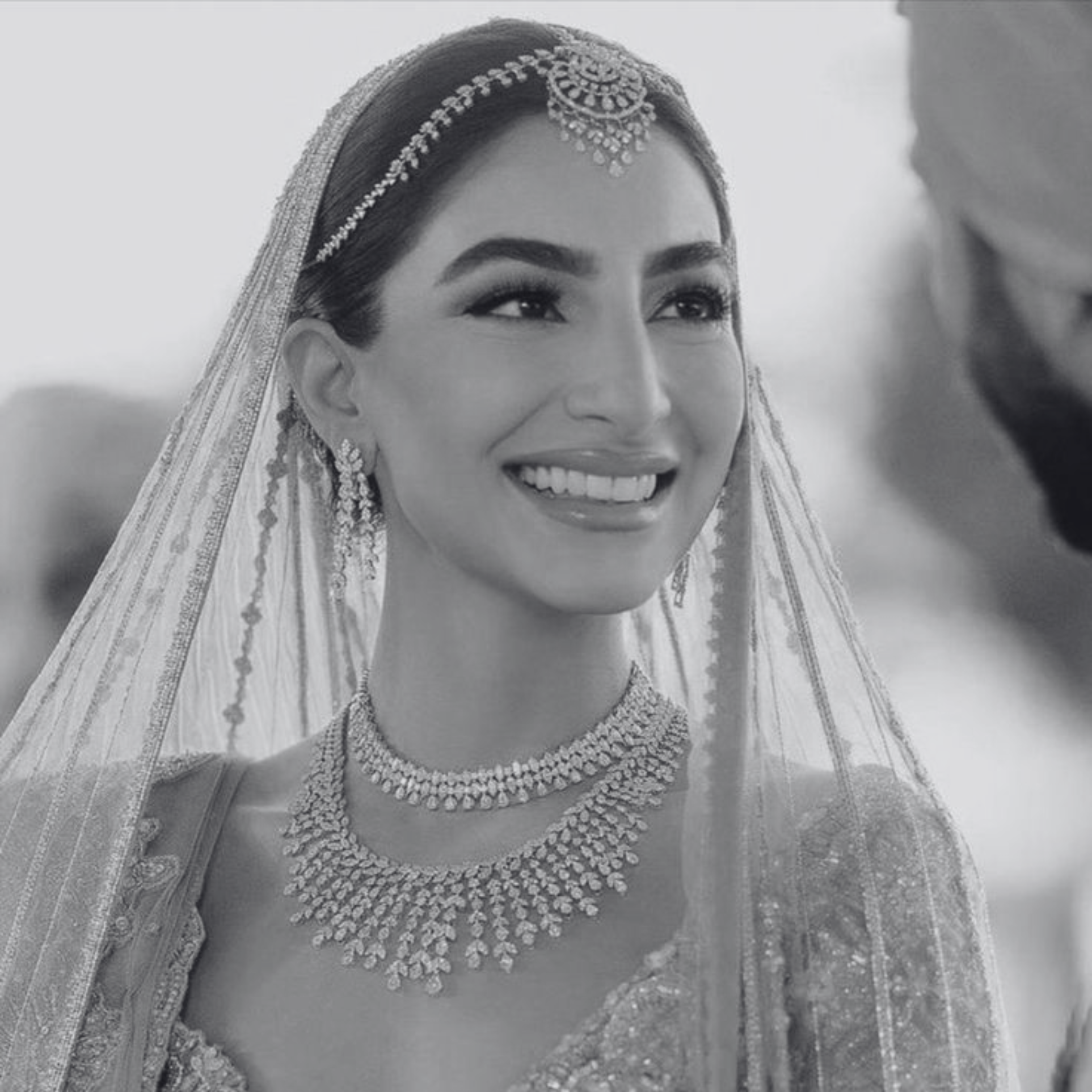 Smiling bride in traditional South Asian bridal jewellery, veil and glamorous bridal makeup