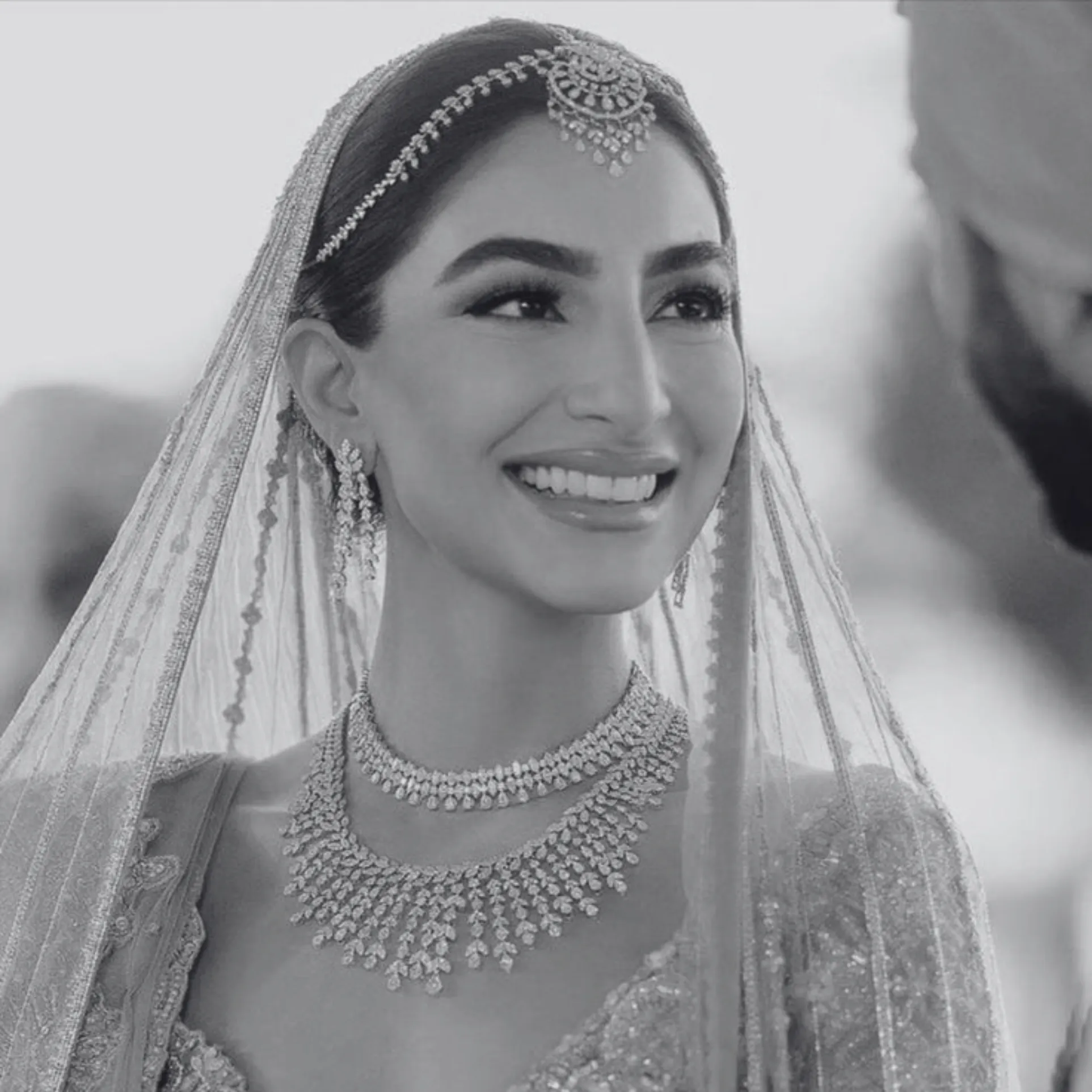 Smiling bride in traditional South Asian bridal jewellery, veil and glamorous bridal makeup