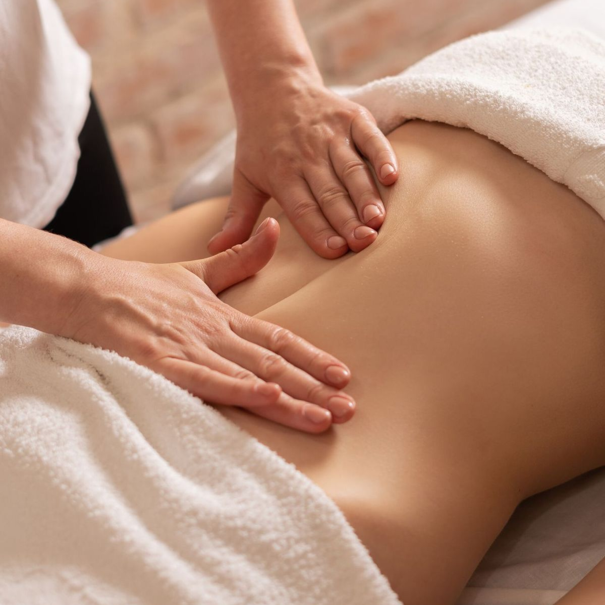 Therapist performing a Brazilian lymphatic drainage massage on the abdomen during an at-home treatment
