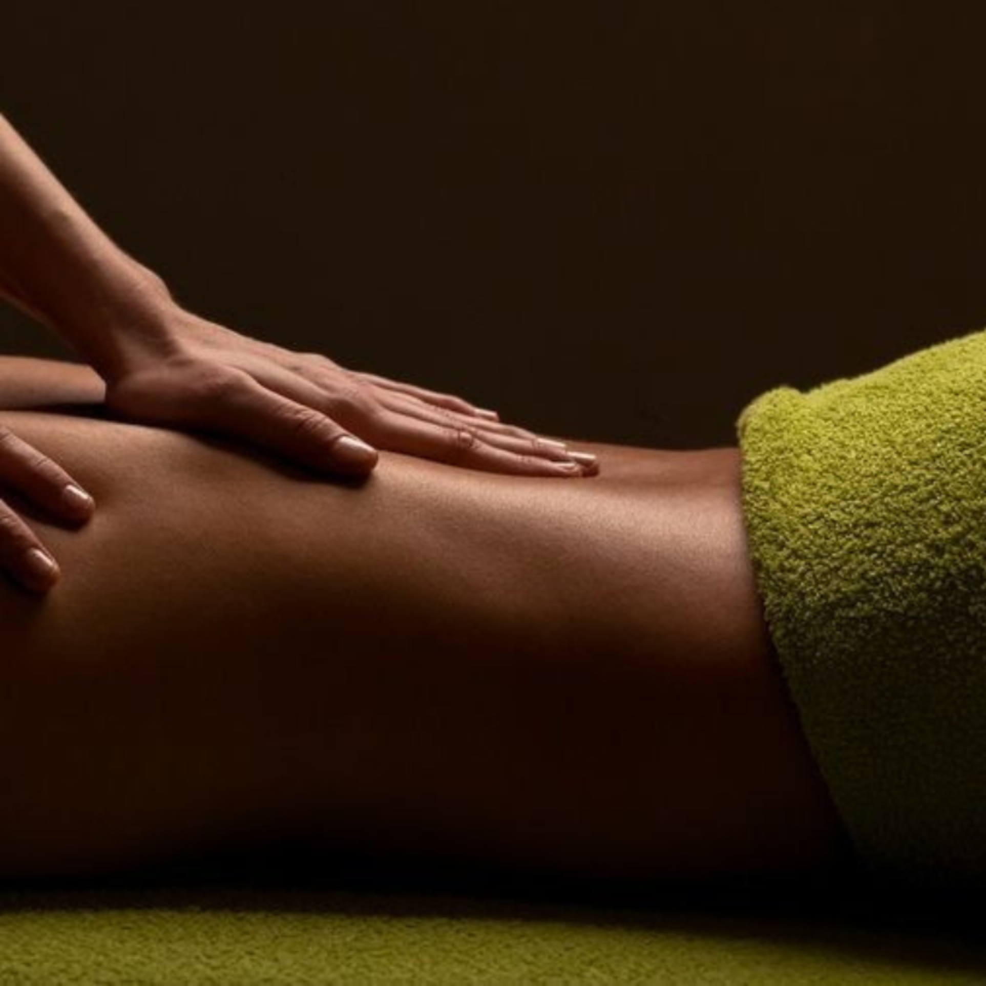 Mobile massage therapist performing a back massage at home