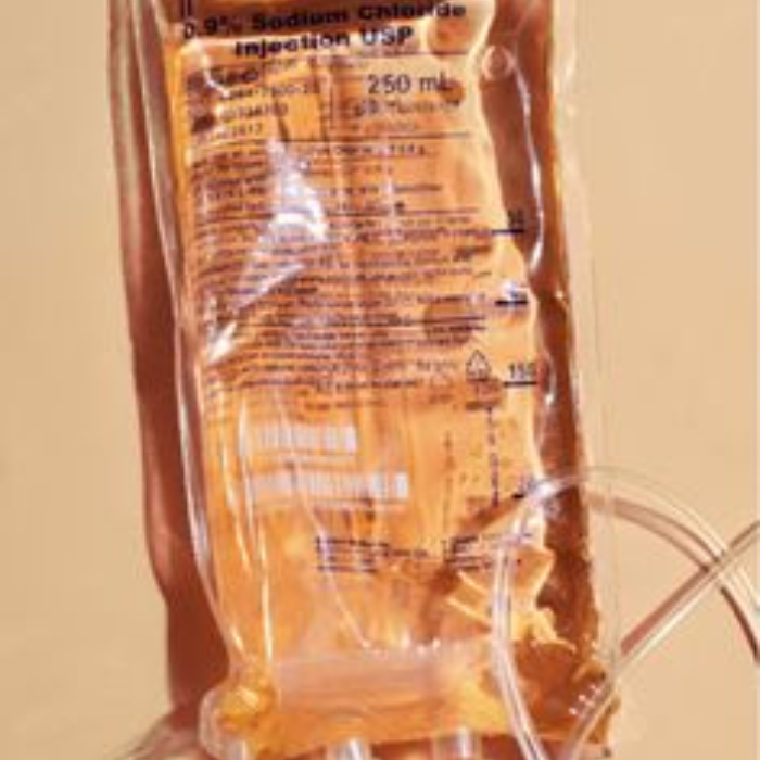 A 250ml IV drip bag filled with orange-coloured solution against a warm beige background.