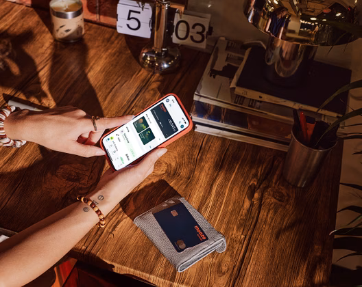 Mobile phone open on the Monzo business screen which Monzo debit card on the table