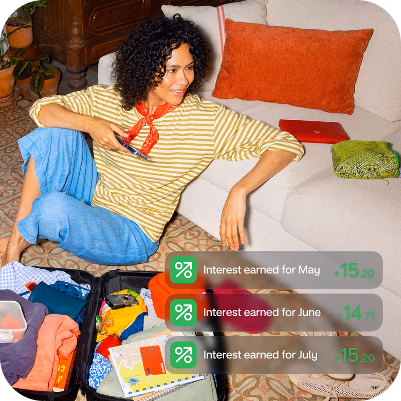 Woman relaxing on a sofa as Monzo notifications show money automatically being added to her savings.