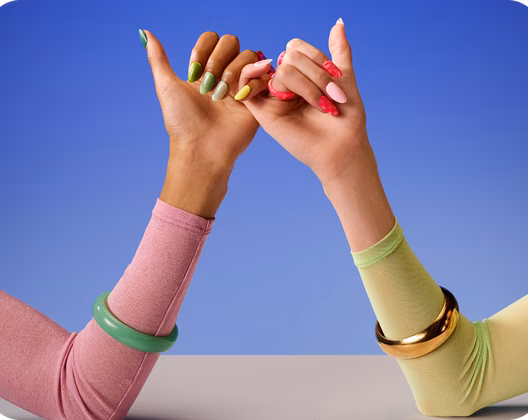 Hands with bright coloured nails – pinky fingers linking 