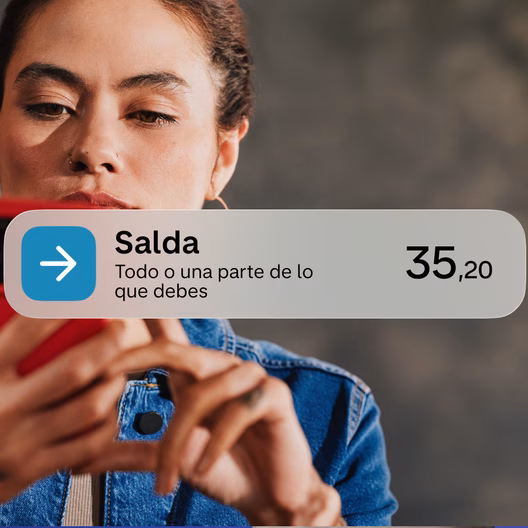 ujer usando su móvil, con Monzo mostrando un saldo pendiente de 35,20 € por liquidar.