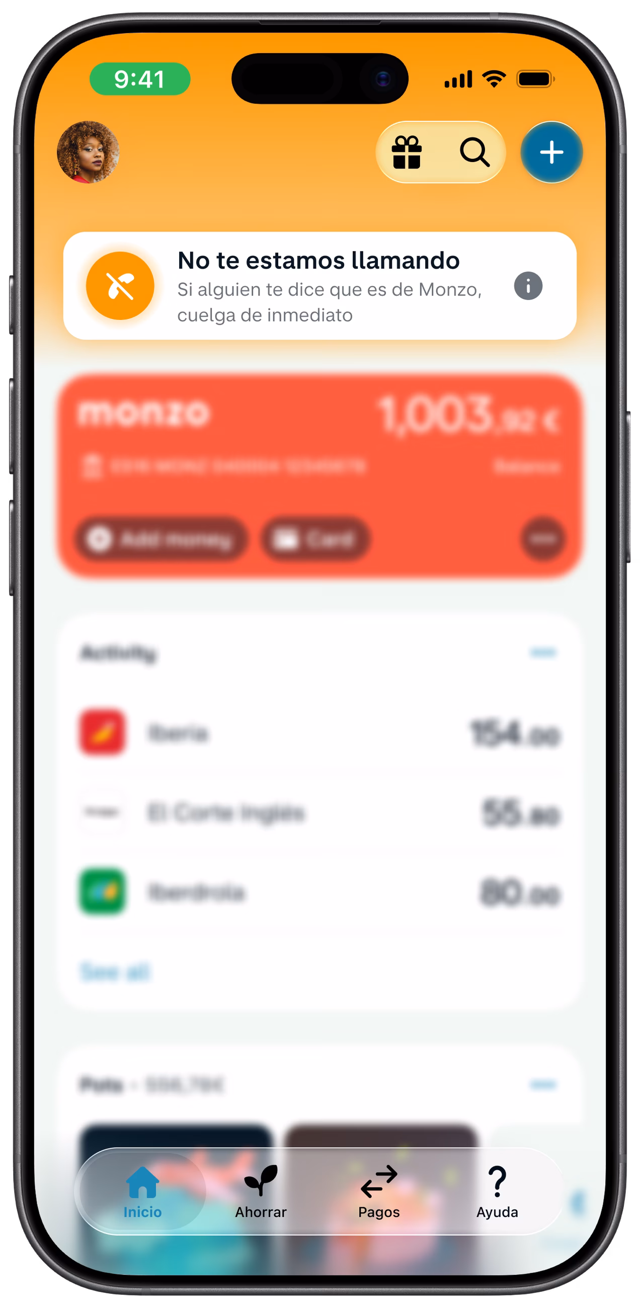 Pantalla de inicio de la aplicación de Monzo que muestra una advertencia que dice «No te estamos llamando» para ayudar a identificar estafas telefónicas. La notificación está encima de una tarjeta de color coral y una lista de movimientos recientes.