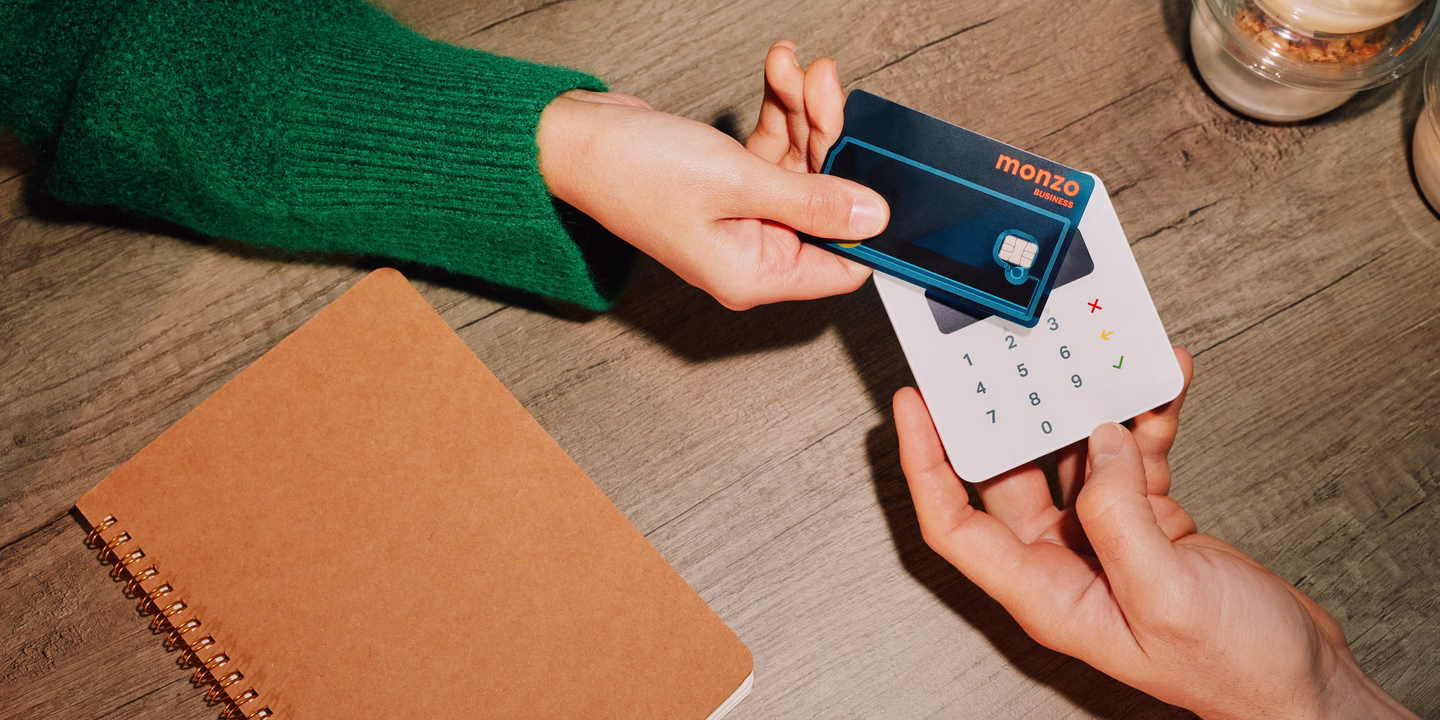 A customer taps their Monzo Business Expense card on a compact card reader to make a contactless payment.
