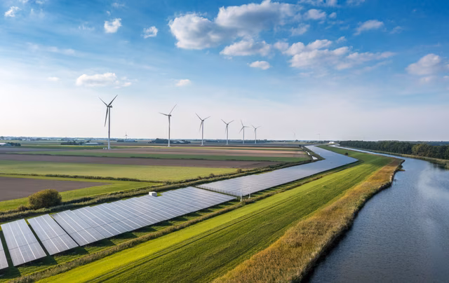 PV Anlagen und Windräder in der Nähe eines Flusses im Kontext nachhaltiger Energieversorgung