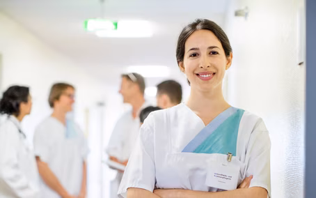 Portrait Krankenschwester mit Kollegen und Kolleginnen im Hintergrund