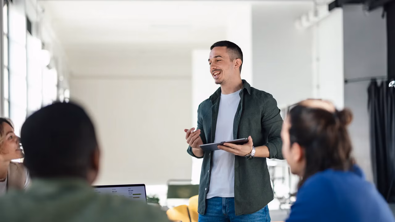 IT Mitarbeiter präsentiert vor Team im modernen Gebäude