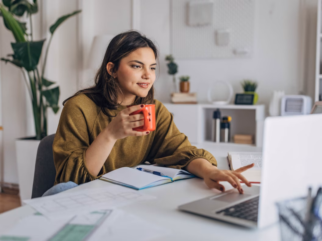 Young woman enjoying coffee while working from home