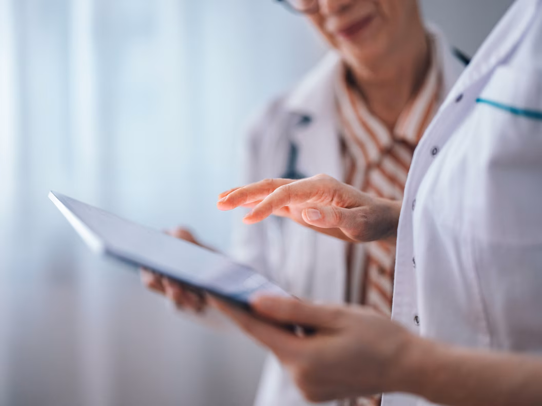 Medizinisches Fachpersonal arbeiten zusammen mit Informationen am iPad