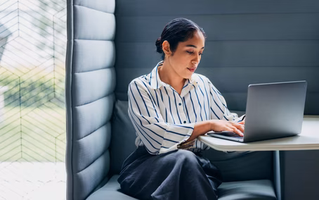 Mitarbeiterin sitzt in Thinkingbox mit ihrem Laptop