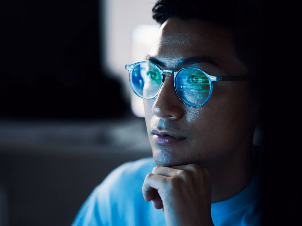 Code reflected in the glasses of an IT employee
