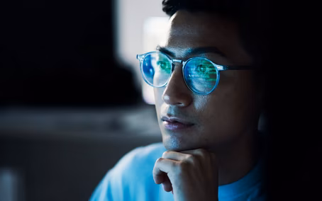 Code reflected in the glasses of an IT employee