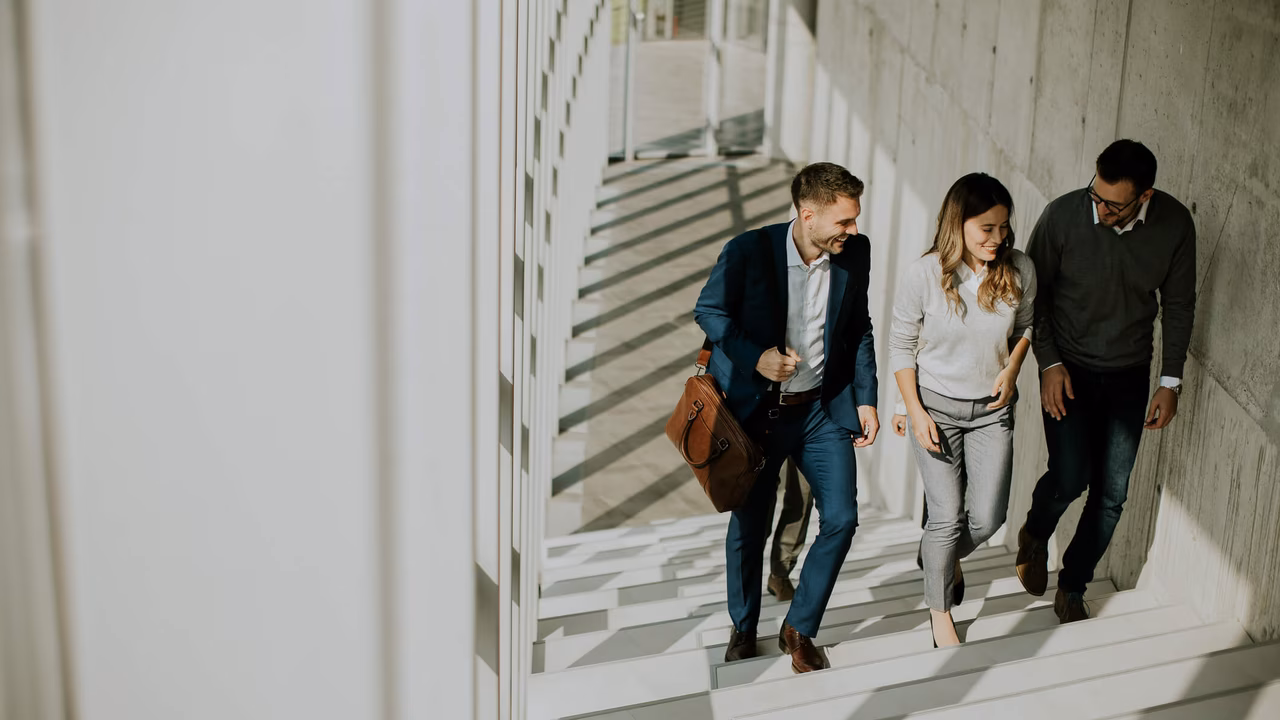 Gruppe von Geschäftsleuten, die an Treppen im Büroflur hinaufsteigen