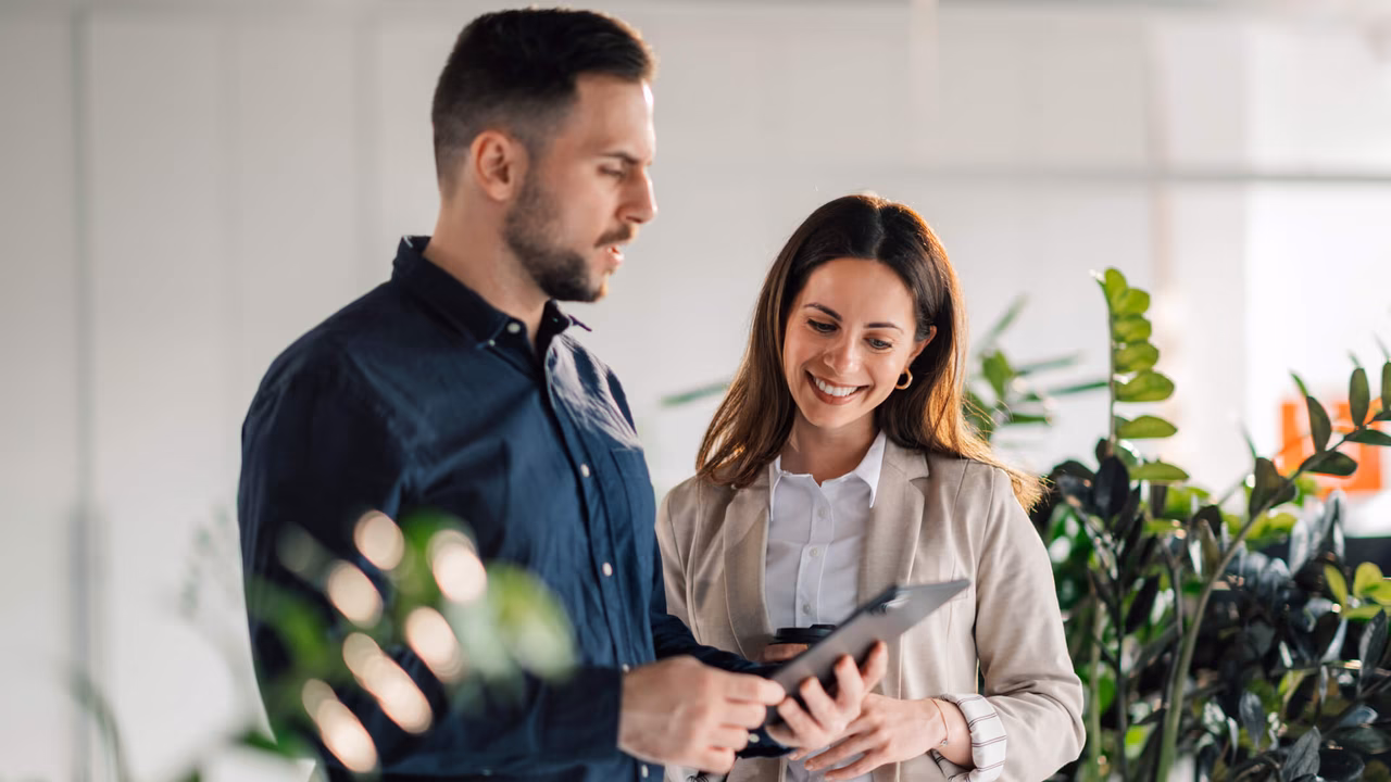 Zwei Mitarbeitende arbeiten in einem modernen Büro an der strategischen Digitalisierung