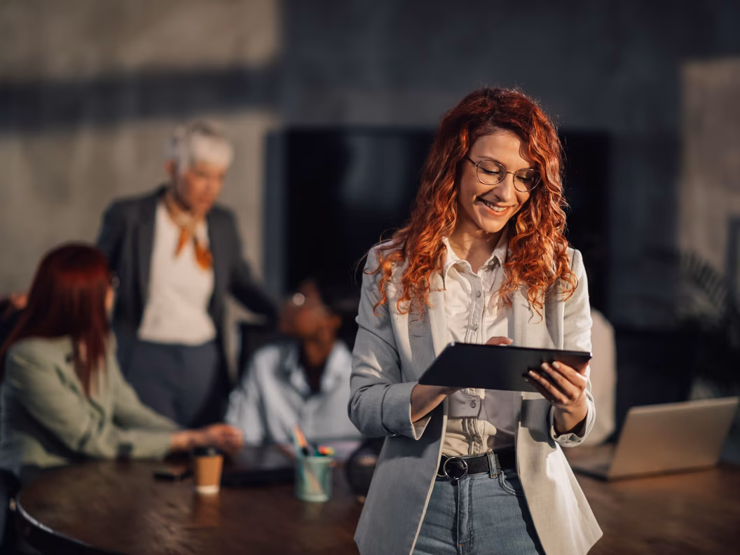 Frau mit Tablet vor einem Team im Kontext sicherer LLM-Hosting-Lösungen