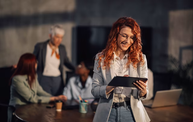 Frau mit Tablet vor einem Team im Kontext sicherer LLM-Hosting-Lösungen