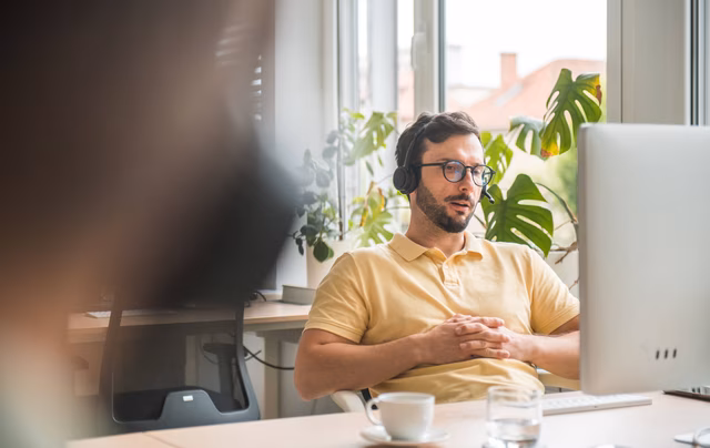 IT Service Mitarbeiter mit Headset in modernem Büro
