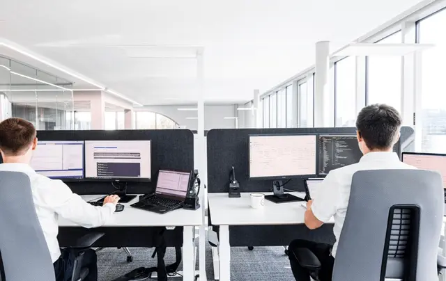 Developer Team sitzt vor Equipment in modernem Büro
