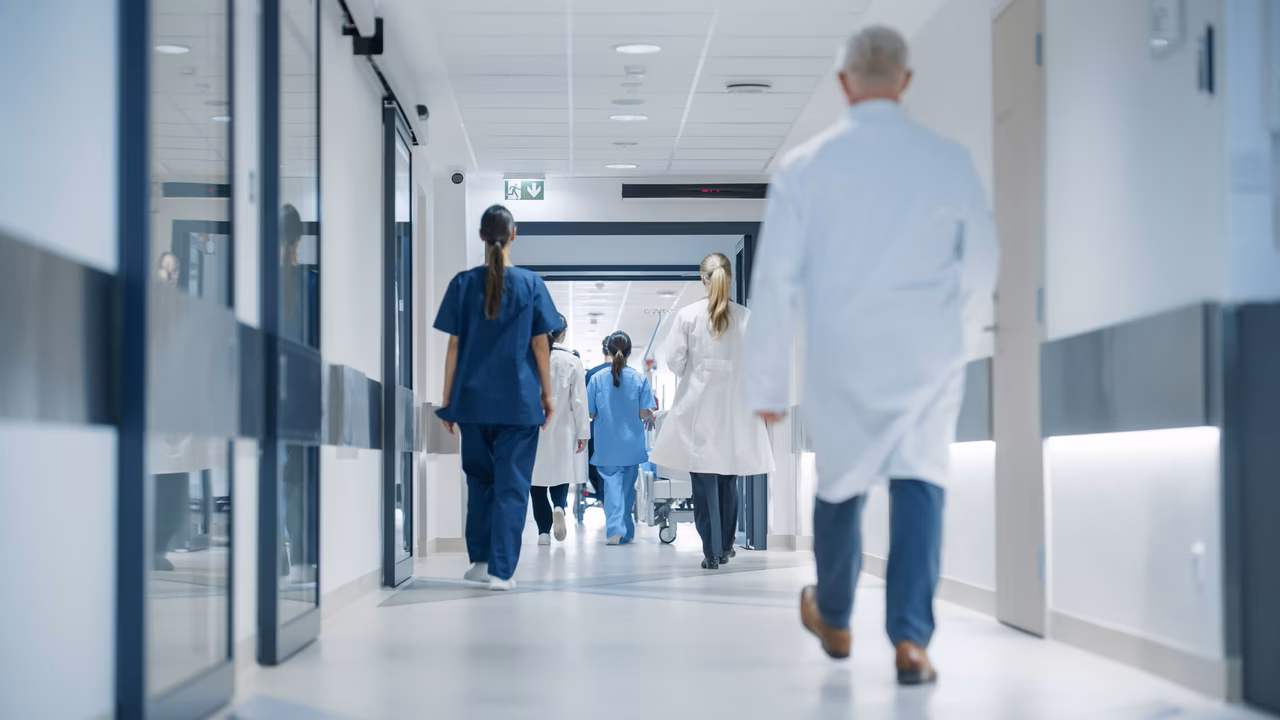 Krankenauspersonal läuft im Betrieb durch einen Korridor