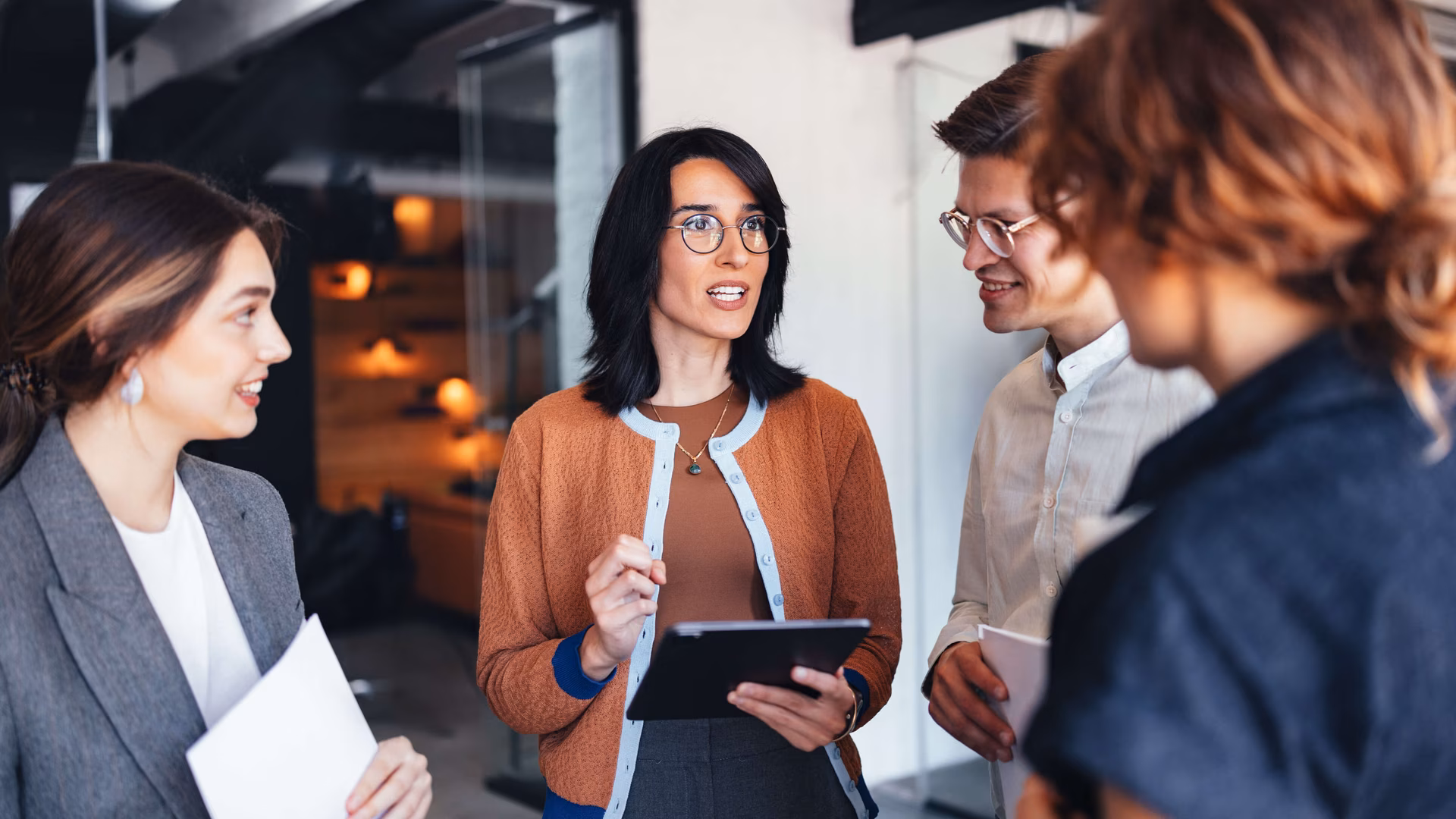 Professionelle Teamdiskussion in einem modernen Büro mit Tablet und Dokumenten für die Zusammenarbeit
