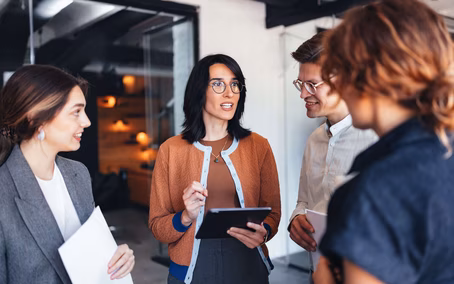 Professionelle Teamdiskussion in einem modernen Büro mit Tablet und Dokumenten für die Zusammenarbeit