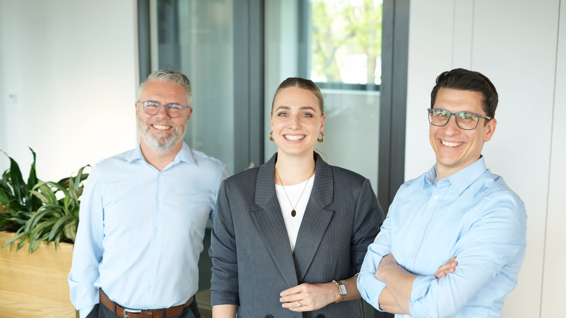 Diverses Team mit strahlendem Lächeln an einem New Work Standort