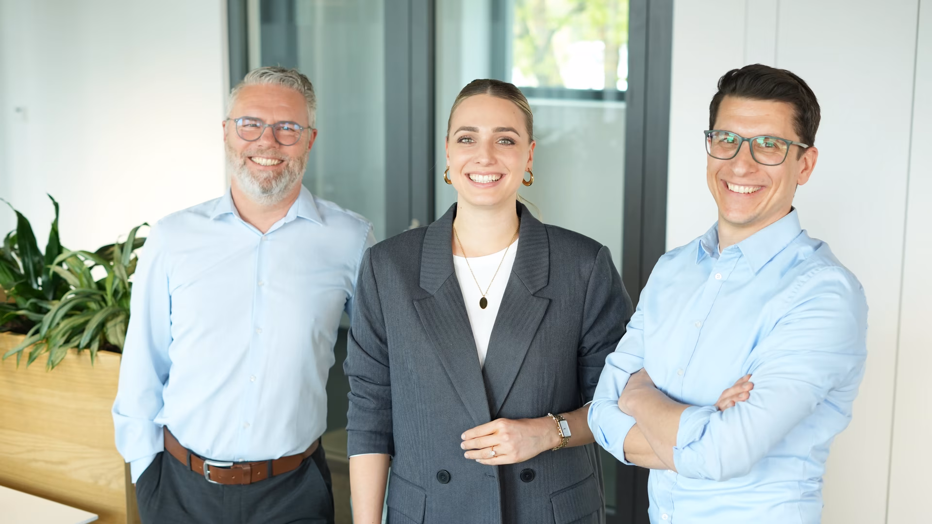 Diverses Team mit strahlendem Lächeln an einem New Work Standort