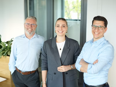 Diverses Team mit strahlendem Lächeln an einem New Work Standort