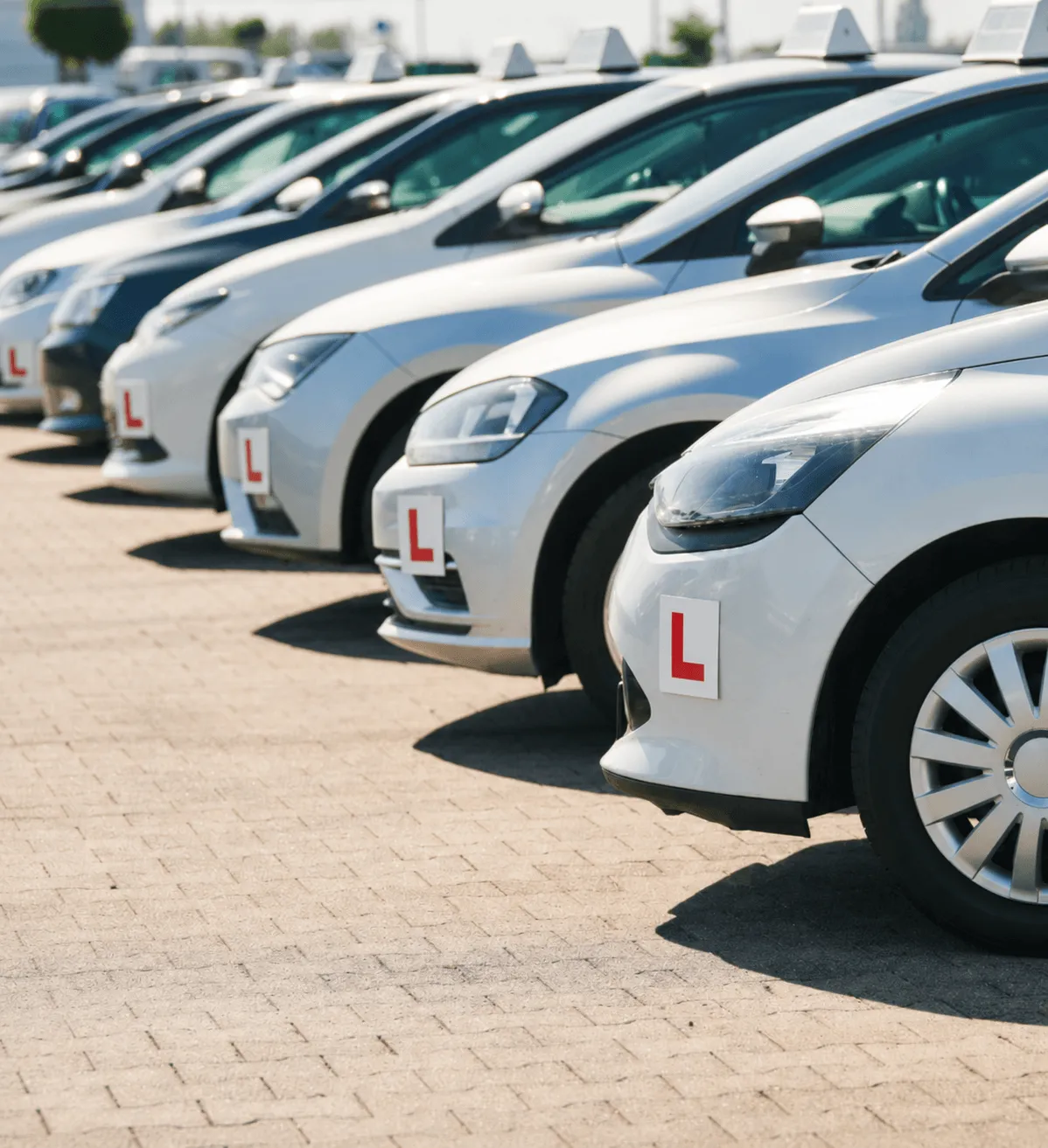 A neat row of modern white cars parked in a lot, representing the fleet of replacement vehicles available through courtesy car cover.