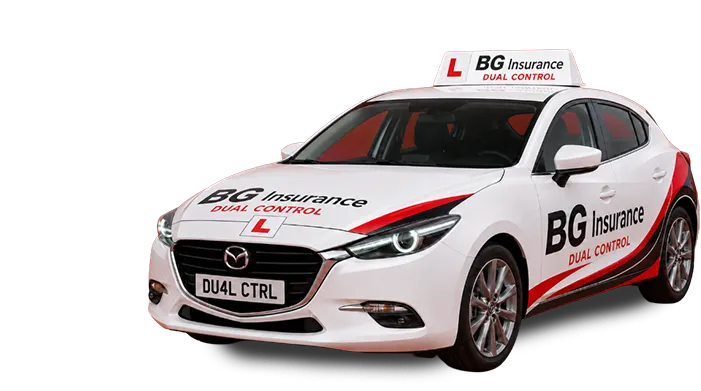 White Mazda driving school car branded “BG Insurance Dual Control” with L plates and roof sign, viewed from front-left angle.