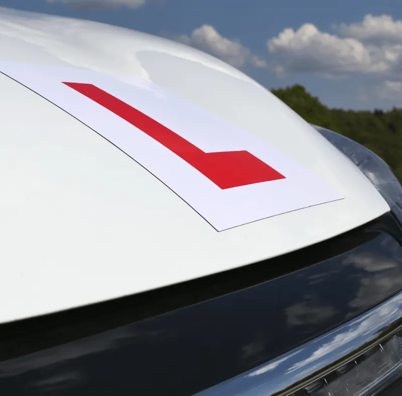 Red learner driver L plate on a car, representing the need for specialist insurance cover for driving instructors.