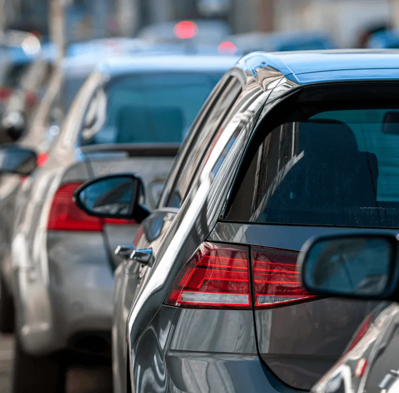 Cars lined up in traffic, representing the difference between standard car insurance and specialist driving instructor insurance.