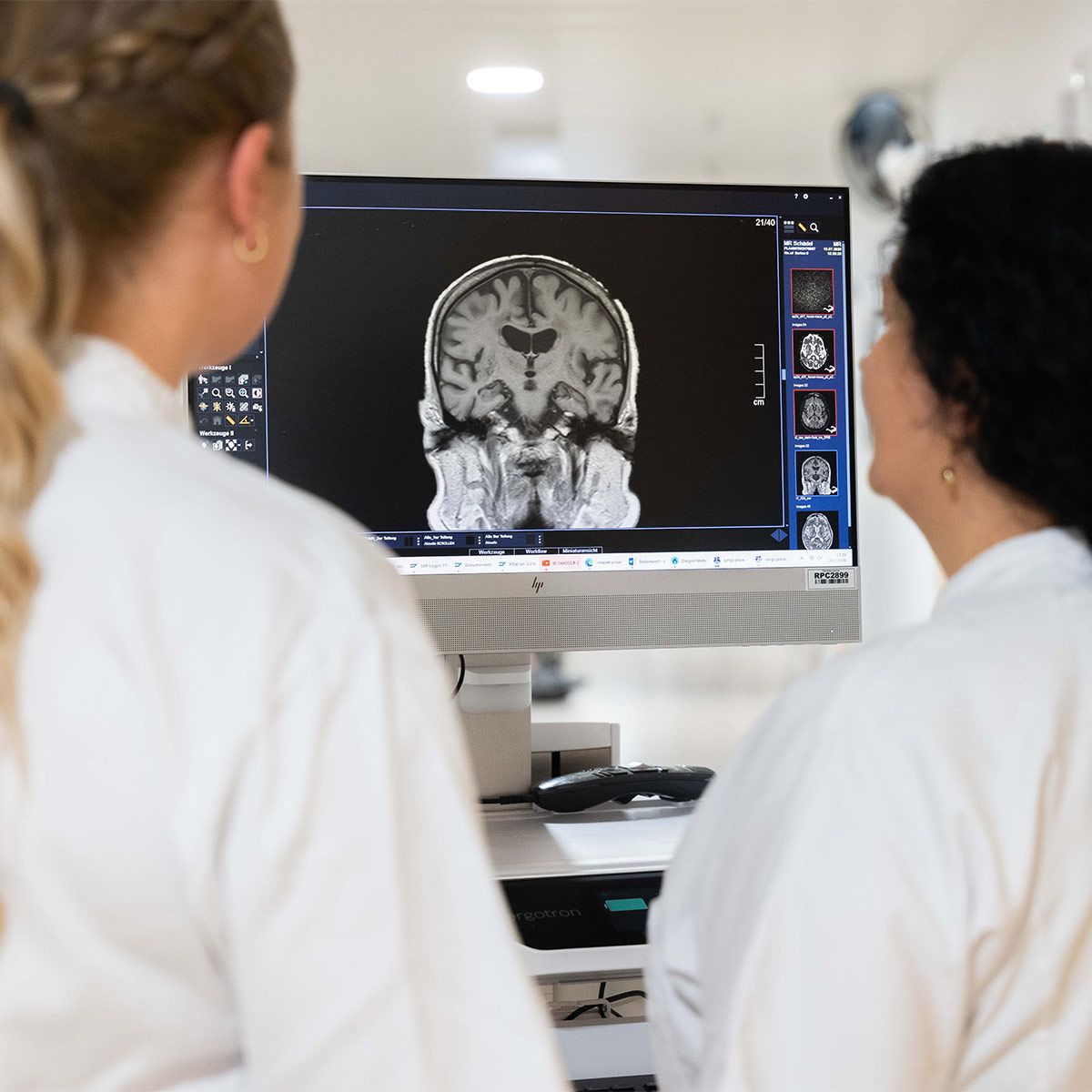 Mitarbeiter der Neurologie blicken auf Bildschirm