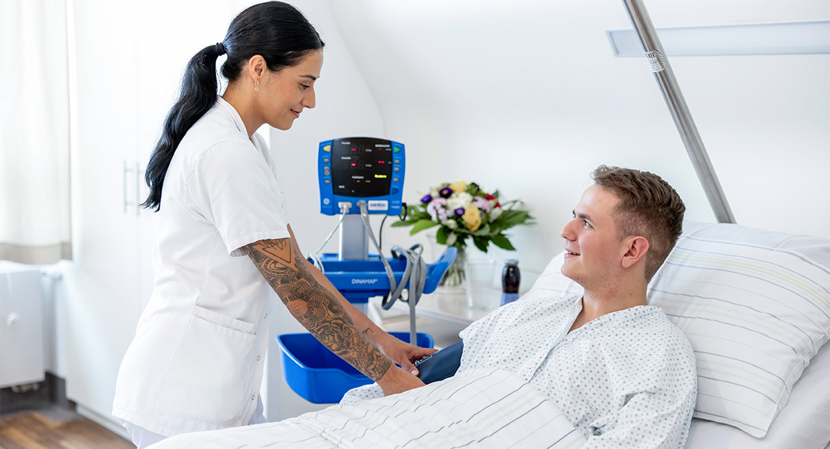 Pflegeperson bei Patient im Zimmer