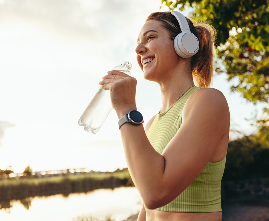 Frau beim Sport, die Wasser trinkt