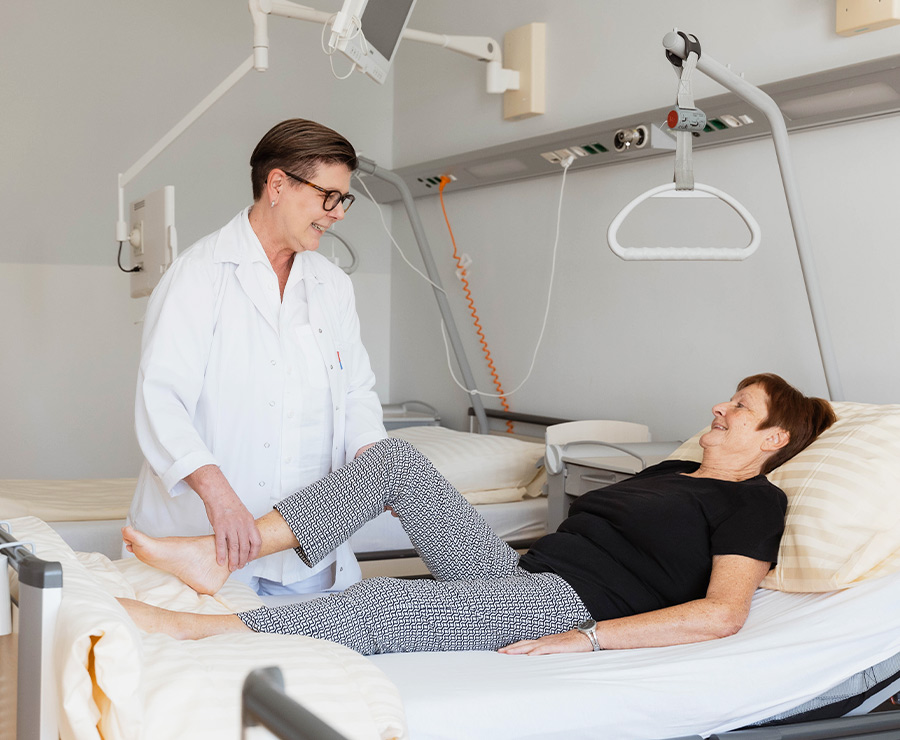 Ärztin steht bei Patientin am Bett