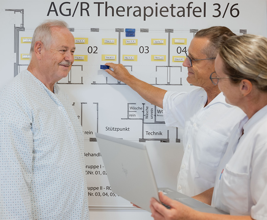 Mitarbeiter*innen besprechen Therapieplan mit Patient auf der AGR